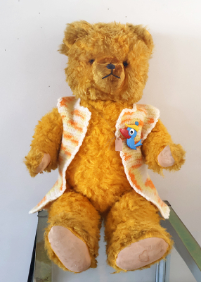 ドイツ　鳥のブローチの付いたベストを着た黄色いベア　鳴き笛入を開く